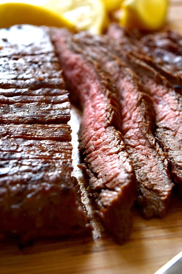 A strip of grilled flank steak showing off the pink grilled meat