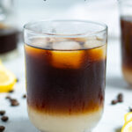Pinterest Pin showing a close up glass with lemonade layered on the bottom and coffee on top with ice cubes