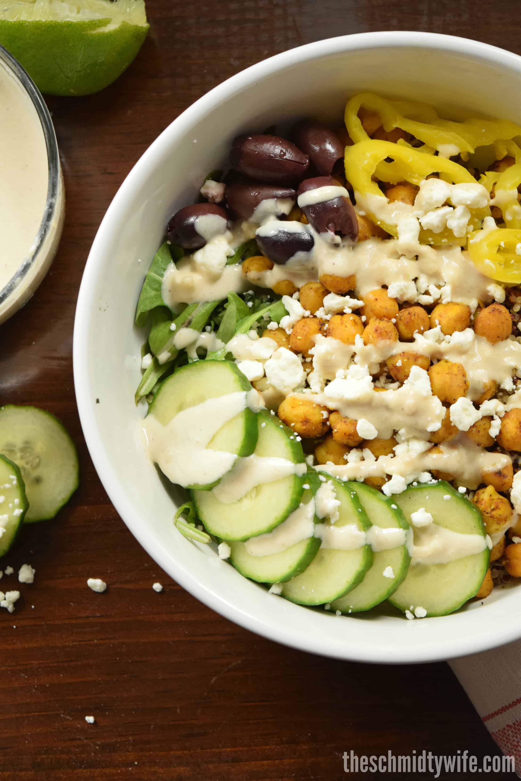 Chickpea Shawarma Buddha Bowl on a wood table with sauces and veggies