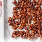 almonds on a sheet pan with the words sweet & spicy candied almonds