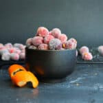 orange zest sugared cranberries in a little black bowl