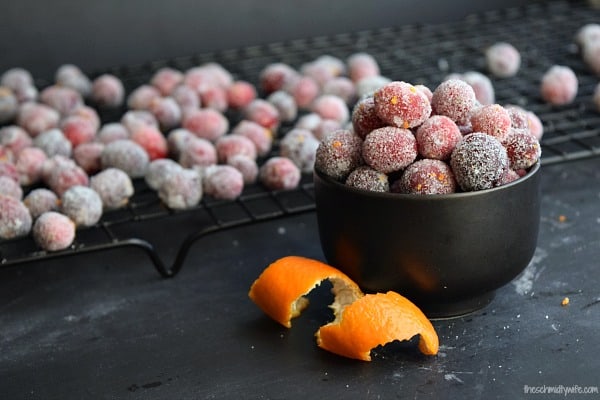 Orange Zest Sugared Cranberries in a bowl next to a wire drying rack