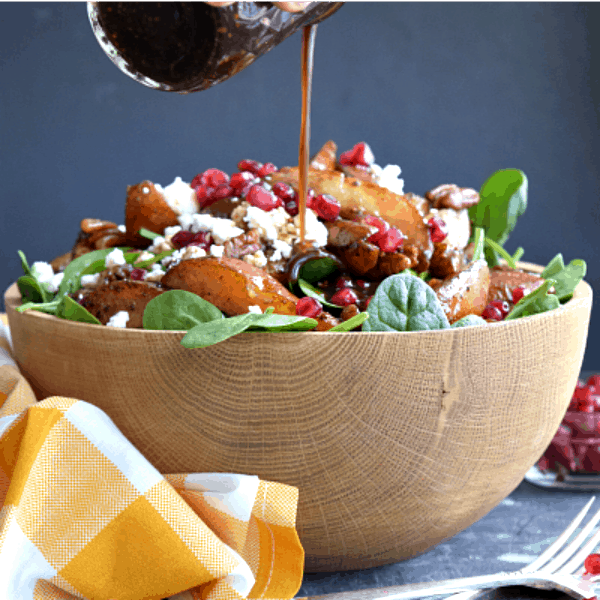 homemade maple balsamic being pored on to Roasted Pear & Pecan Salad