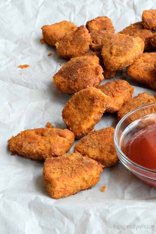 Healthier Baked Chicken Nuggets laying next to a bowl of ketchup