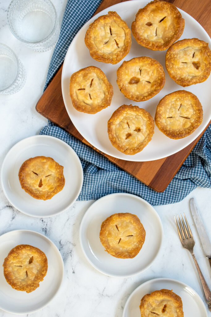 Overhead view of a large plate with many and small plate with one mini turkey pot pie.