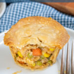 Pinterest Pin with text 'Leftover Mini Turkey Pot Pies', image with min pot pies on a white plate.