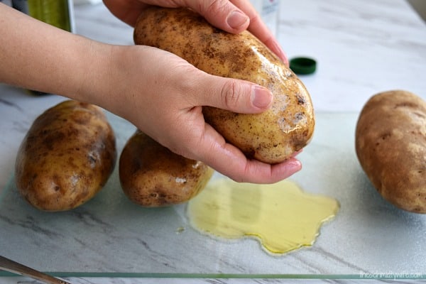 oiling a potato to get ready for the oven 