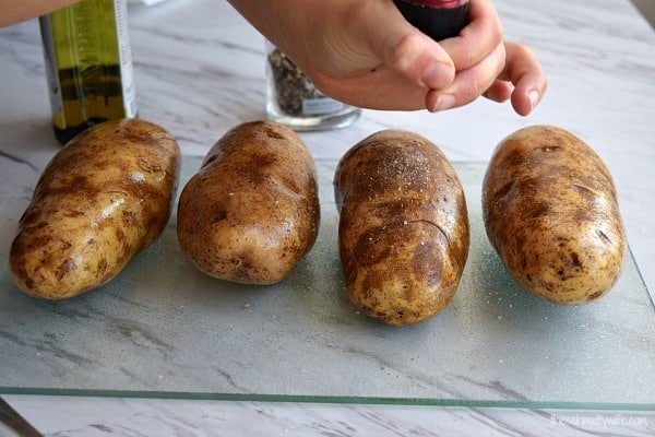 salting a potato on a cutting board for the oven