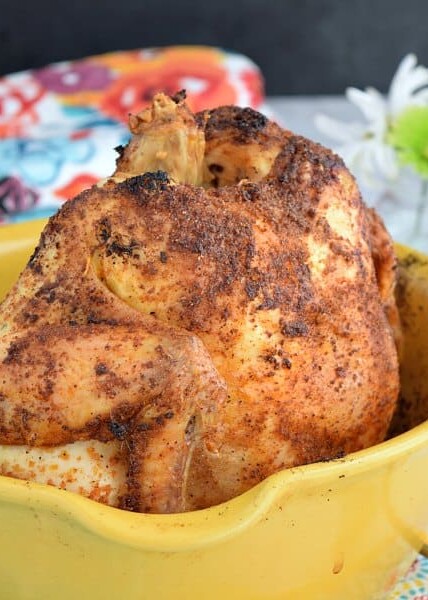 a crispy roasted chicken in a yellow roasting container