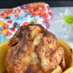 a whole roasted beer can chicken in a yellow platter