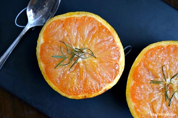 Honey Broiled Grapefruit on a black plate with a spoon
