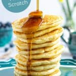 maple syrup being poured onto a stack of pancakes