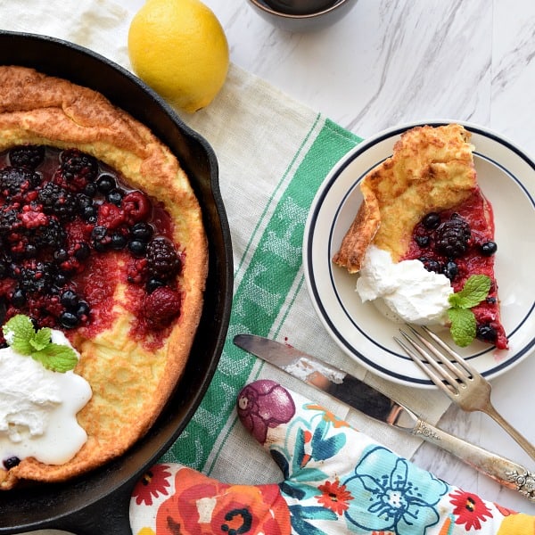 a slice of Dutch Baby with Berries and Whipped Cream