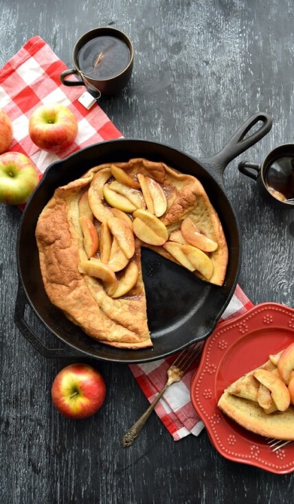 Overhead Cinnamon Apple Topped Dutch Baby with a slice cut out