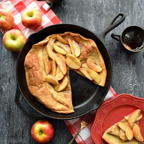 Overhead Cinnamon Apple Topped Dutch Baby with a slice cut out