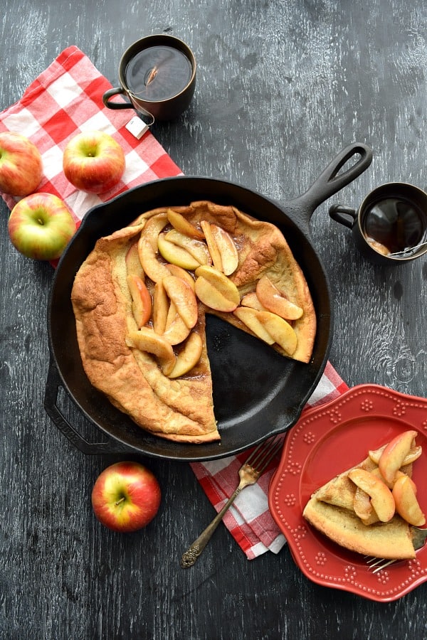 Overhead Cinnamon Apple Topped Dutch Baby with a slice cut out