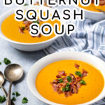 Pinterest Pin with text overlay, Roasted Butternut Squash Soup, image of three bowls of soup on a table next to spoons and a towel, the soup is garnished with bacon.