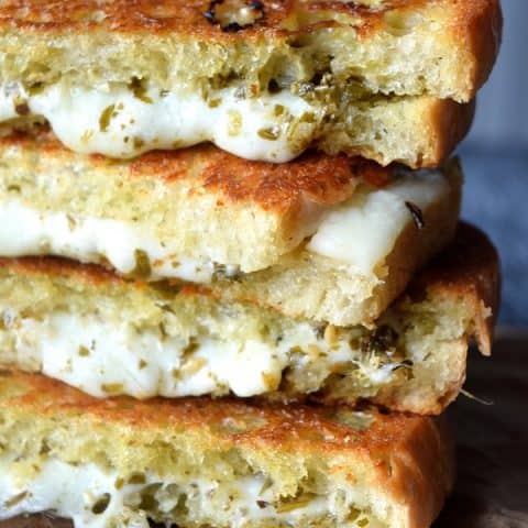Pesto Grilled Cheese stacked up with melting cheese and pesto