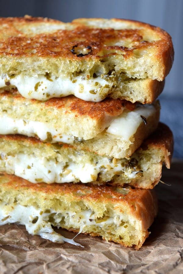 Pesto Grilled Cheese stacked up with melting cheese and pesto