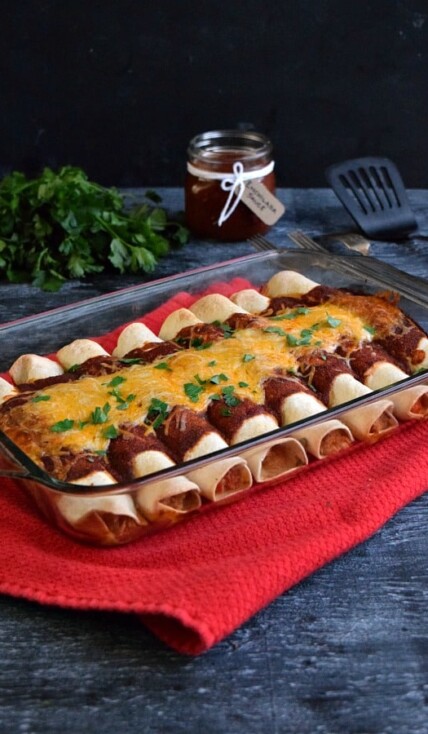 Side view of casserole dish full of leftover chicken enchiladas