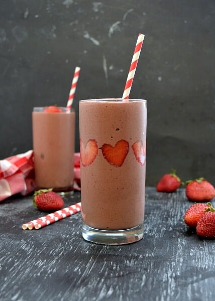 square image of 2 strawberry chocolate smoothies, strawberries stuck like hearts in the side of the smoothie