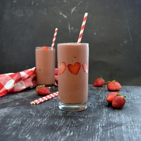 2 strawberry chocolate smoothies, strawberries stuck like hearts in the side of the smoothie