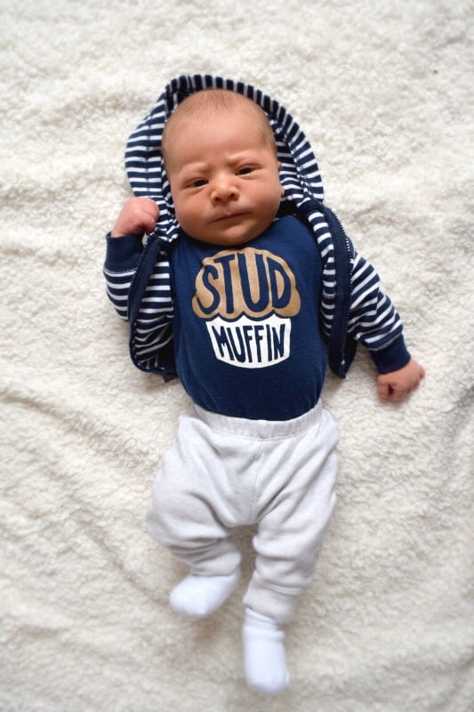 Overhead picture of baby in a ‘stud muffin’ onesie 