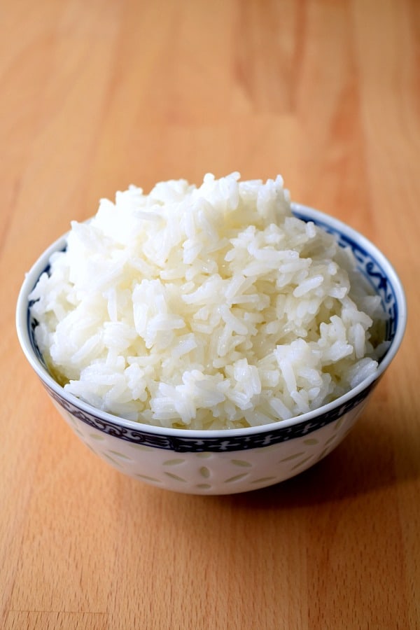 a small bowl of rice on a cutting board
