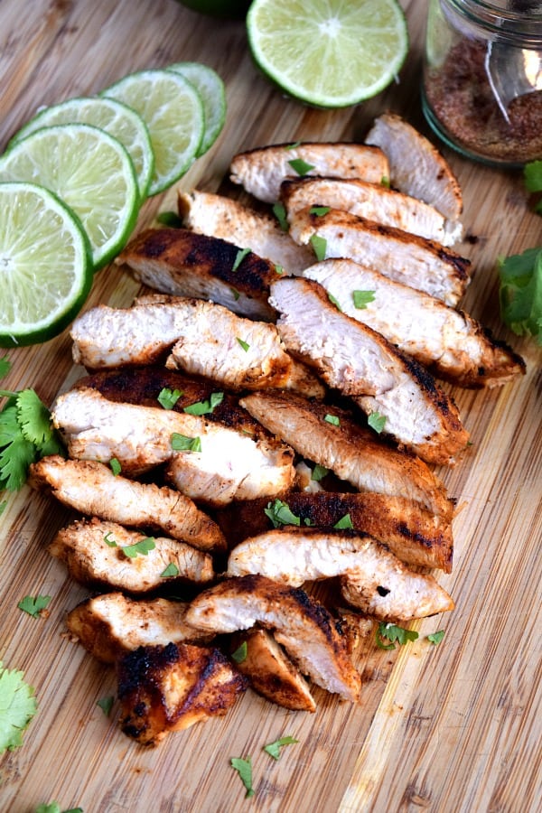 Southwest Chicken sliced and piled up on a cutting board with limes and cilantro