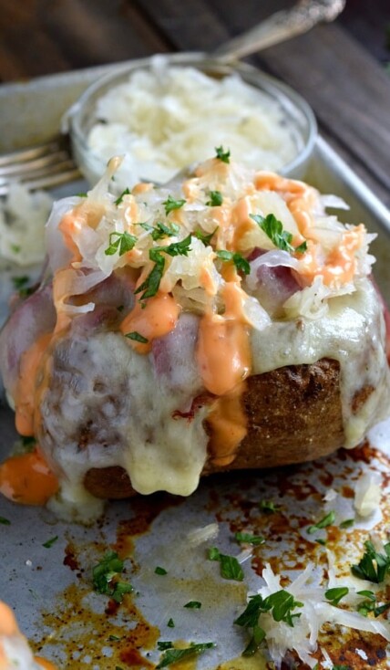 Reuben Stuffed Baked Potato covered with sauerkraut and dripping with 1,000 island dressing
