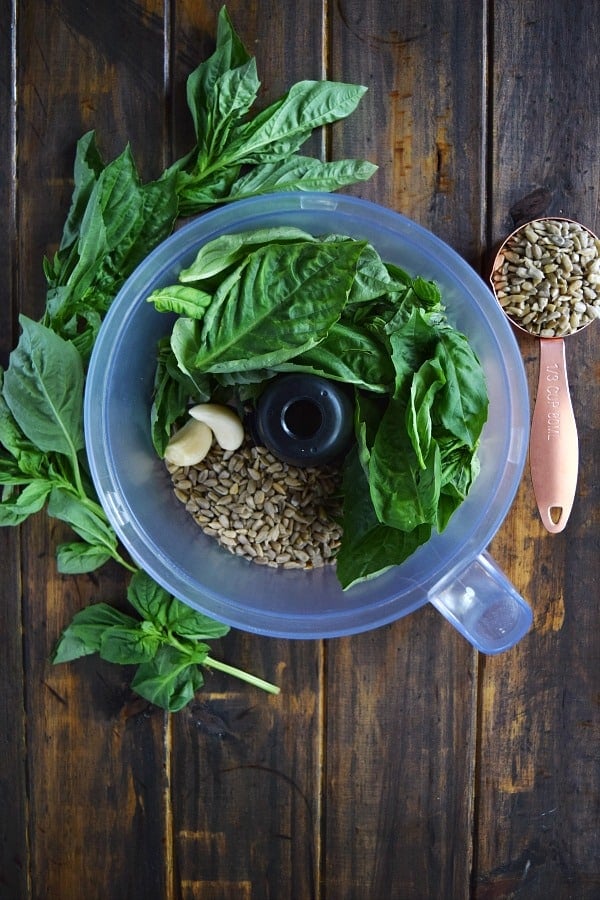 Sunflower Seeds, Basil, and garlic in a food processor, waiting to be made into sunflower seed basil pesto