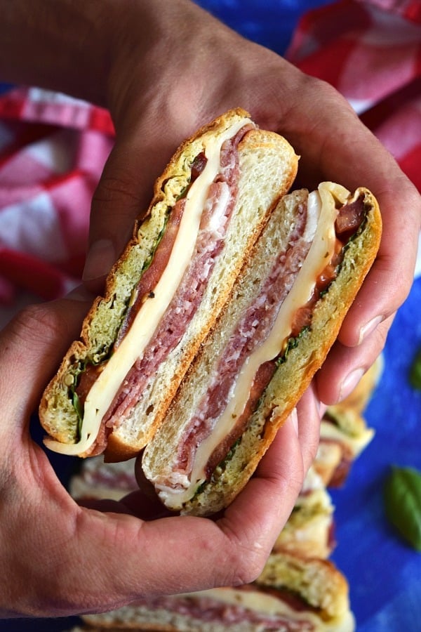 hands holding an Italian Pressed Picnic Sandwich ready to eat
