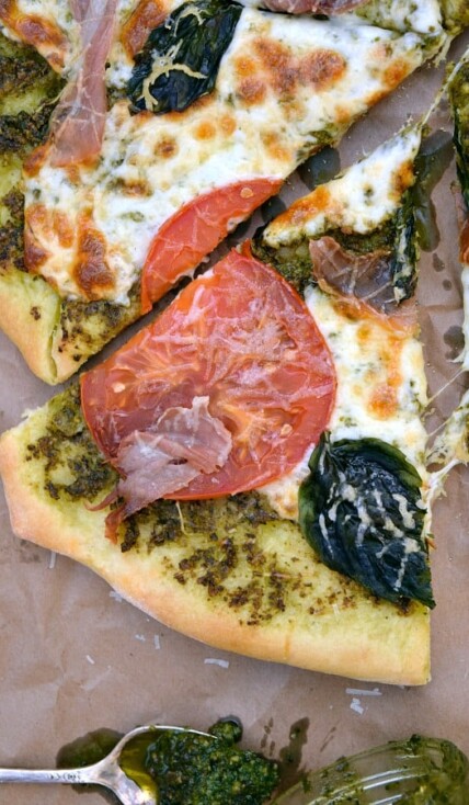a slice of Pesto Pizza with Prosciutto, Tomatoes, and Mozzarella