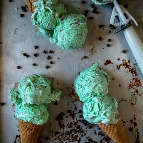 Homemade Mint Chocolate Chip Ice Cream - 3 cones laying on a sheet