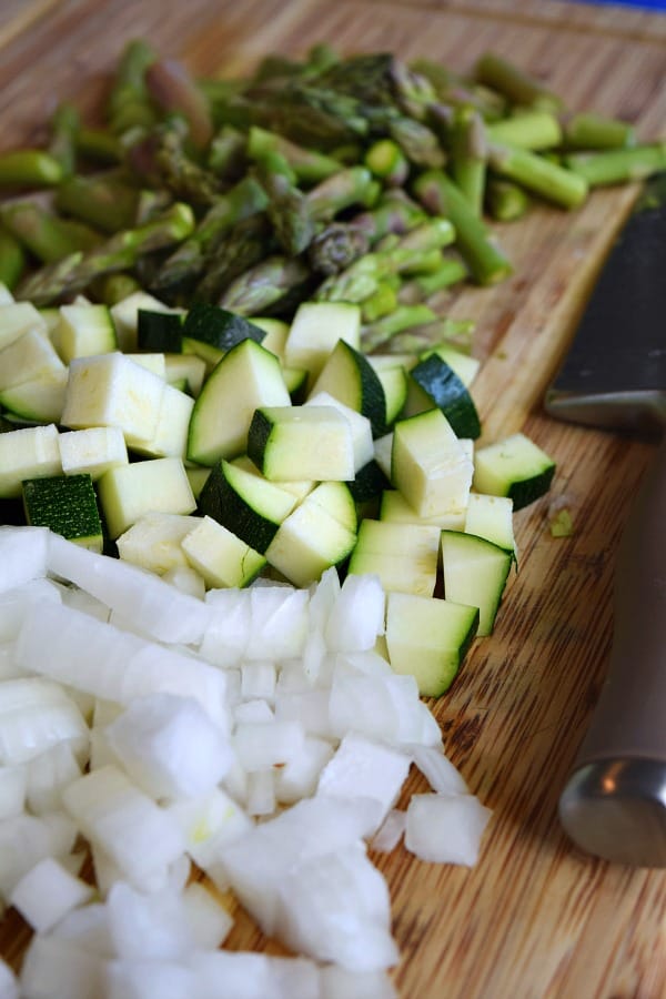 Onions, zucchini, and asparagus cut up to make this vegetable filled Summer Spaghetti Carbonara