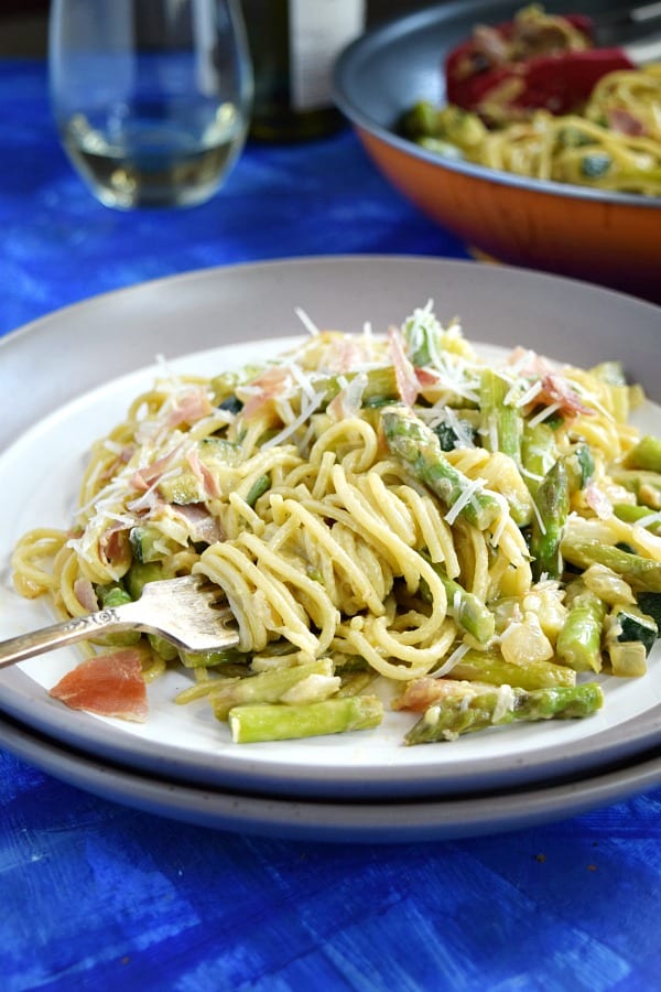 Summer Spaghetti Carbonara on a plate with a fork full of twisted pasta