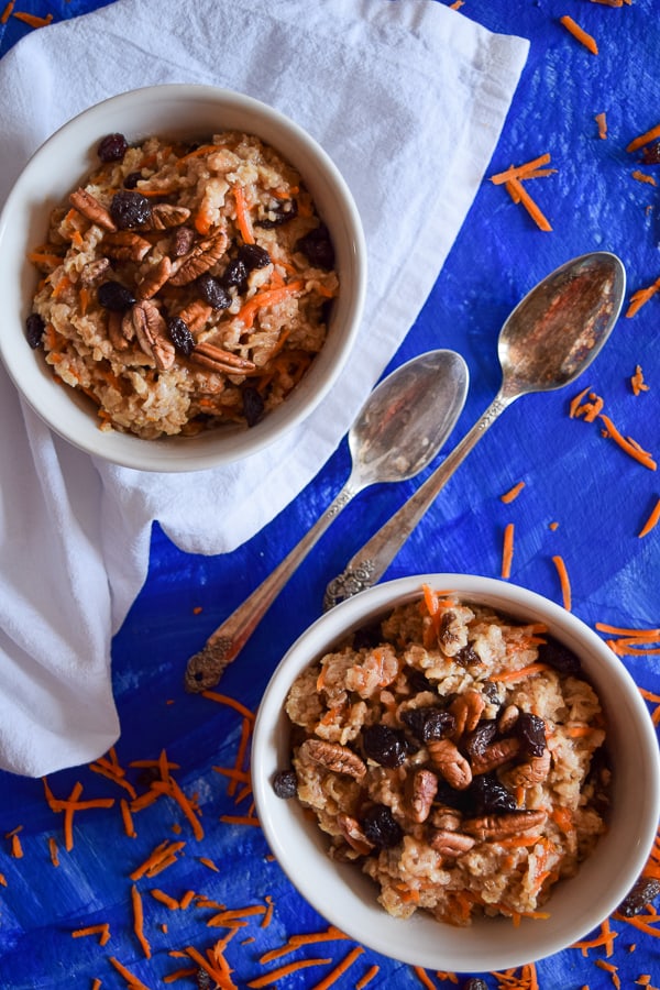 Clean Eating Carrot cake Oatmeal in two bowls topped with nuts and raisins ready to eat