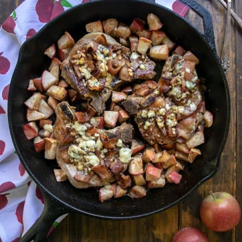 Overhead Shot of Apple Bacon Blue Smothered Pork Chops in a cast iron skillet