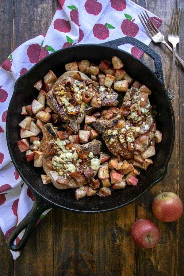 Overhead Shot of Apple Bacon Blue Smothered Pork Chops in a cast iron skillet