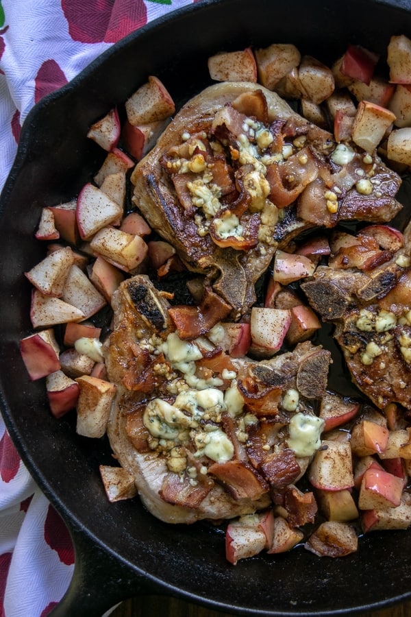 Apple Bacon Blue Smothered Pork Chops in a skillet with diced apples