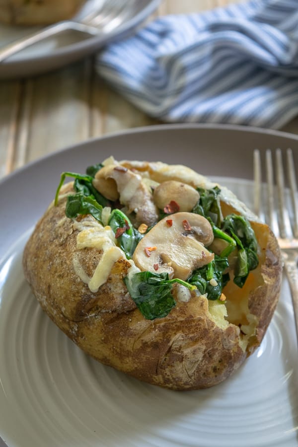 Spinach Mushroom Stuffed Baked Potatoes on a plate with a fork
