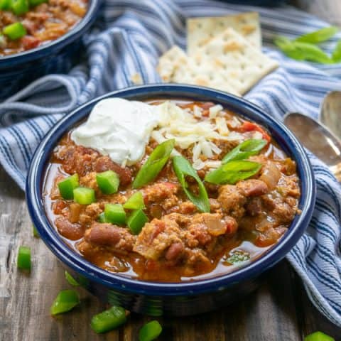 a full bowl of turkey chili with garnishes