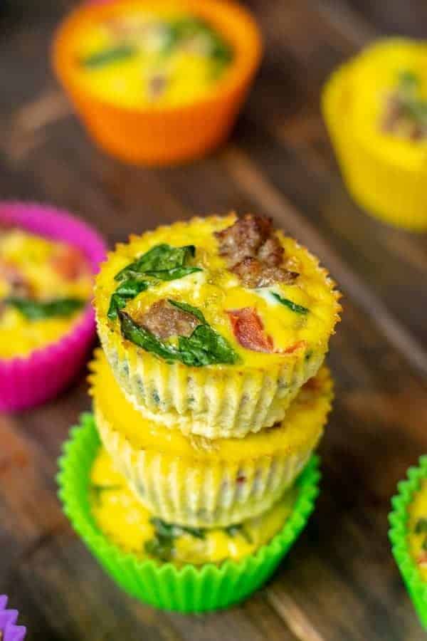 close up of a freshly made spinach, sausage, tomato egg muffin