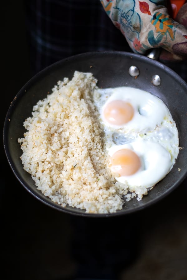 cauliflower rice and fried eggs in a skillet