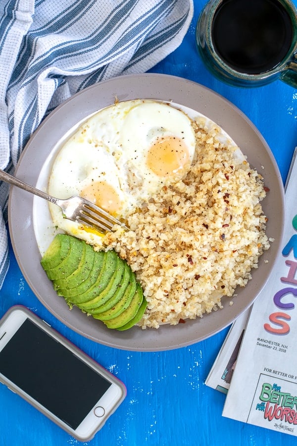 overhead shot of a plate full of breakfast eggs with cauliflower rice and avocado