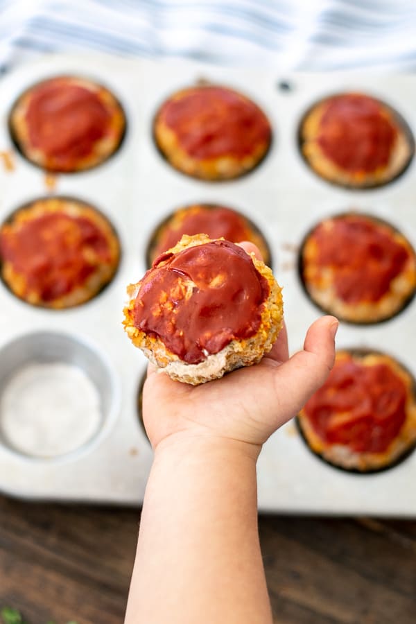 hand holding a turkey veggie meatloaf muffins