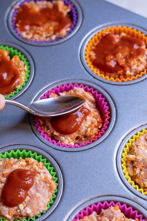 ketchup being spread on a turkey meatloaf muffin