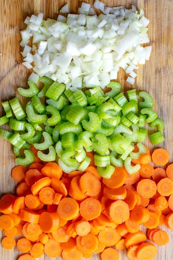 onions, carrots, celery (mirepoix) on a cutting board for the soup