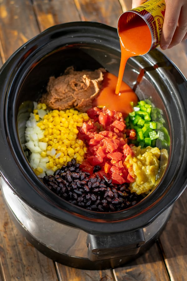 pouring enchilada sauce into the crockpot