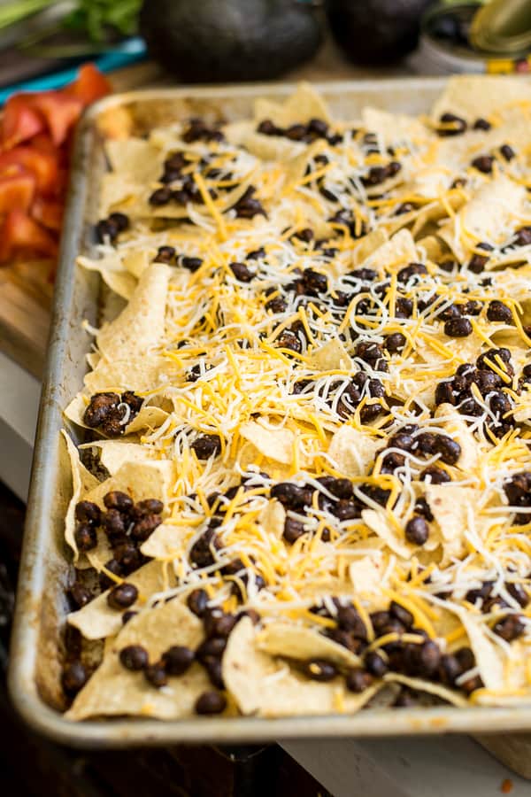 step two, add chips, beans, and cheese to a sheet pan